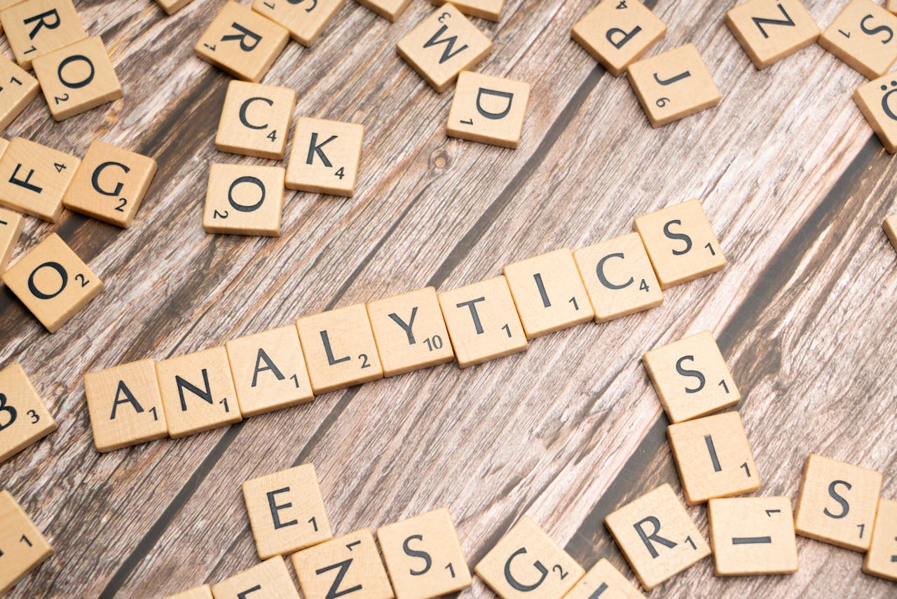 service-02 Scrabble tiles spelling 'Analytics' on a wooden surface, symbolizing data analytics concept.
